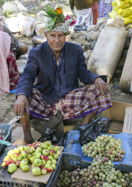 Portrait of a yemeni man with flowers headwear selling fruits, Amran Governorate, Hababah, Yemen