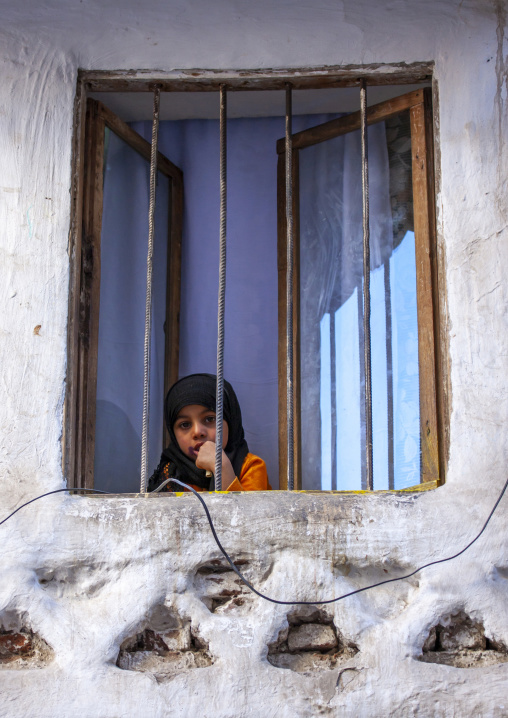 Portrait of a yemeni girl behind the bars of a window, Amanat Al-Asemah, Sanaa, Yemen