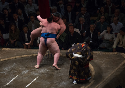 Two sumo wrestlers fighting at the ryogoku kokugikan arena, Kanto region, Tokyo, Japan